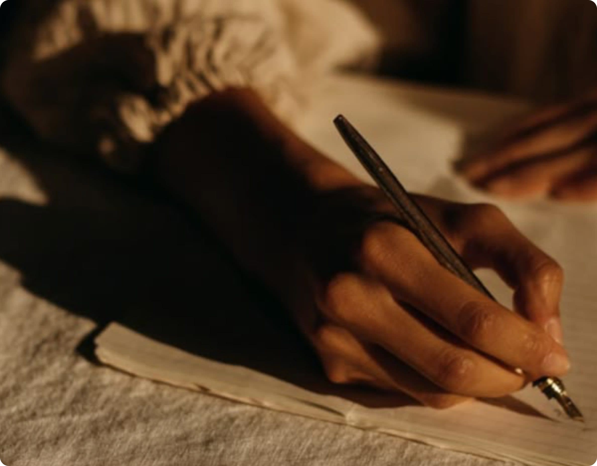 A hand writing in a journal in warm natural light